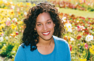 Woman smiling in front of flowers